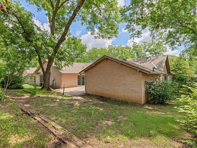 1525 Pecan Pl, Bartlesville, OK 74003 - view of property exterior with a patio area and brick siding