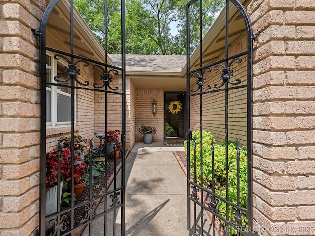 1525 Pecan Pl, Bartlesville, OK 74003 - view of exterior entry with brick siding and roof with shingles