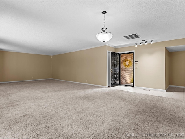 1525 Pecan Pl, Bartlesville, OK 74003 - unfurnished room featuring a textured ceiling, light carpet, crown molding, track lighting, and light tile patterned floors