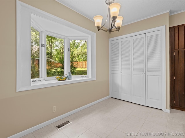 1525 Pecan Pl, Bartlesville, OK 74003 - unfurnished bedroom featuring a chandelier, multiple windows, ornamental molding, a closet, and light tile patterned flooring