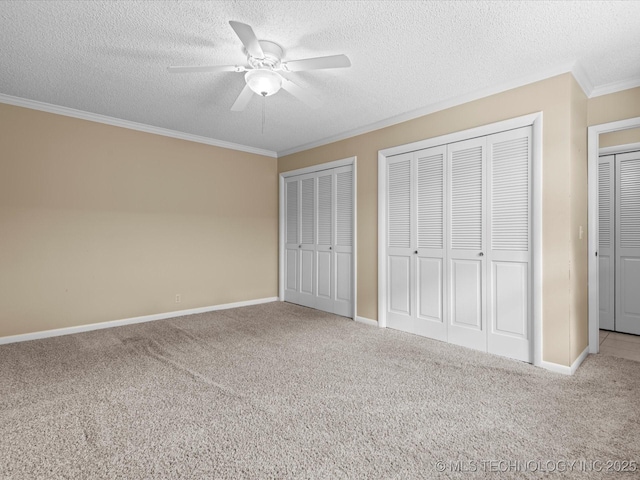 1525 Pecan Pl, Bartlesville, OK 74003 - unfurnished bedroom with ornamental molding, carpet flooring, two closets, a textured ceiling, and a ceiling fan