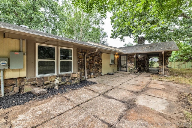 4235 E 104th St, Tulsa, OK 74137 - view of front of home featuring stone siding, a patio area, and a chimney