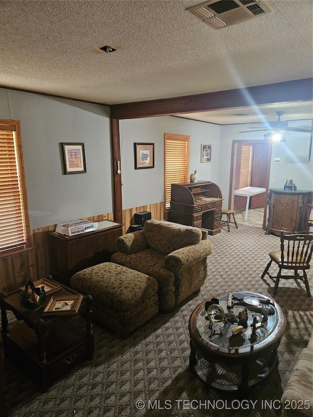 307 N Hartman Ave, Cushing, OK 74023 - living room featuring carpet, wainscoting, a textured ceiling, and wooden walls