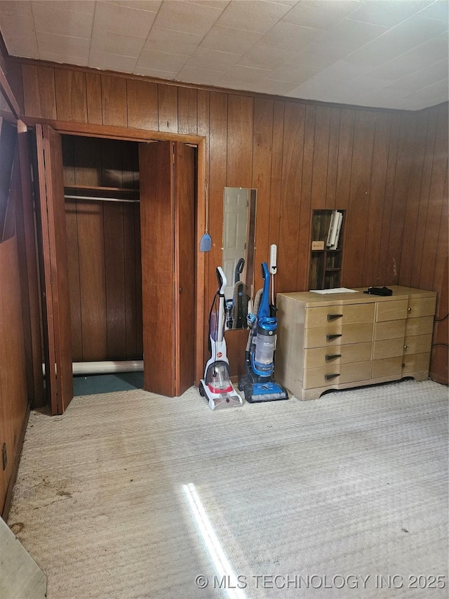307 N Hartman Ave, Cushing, OK 74023 - carpeted bedroom featuring wooden walls and a closet