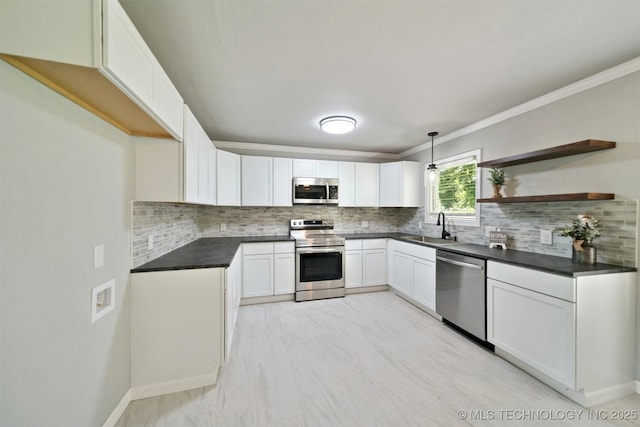 412 W Roger St, Oilton, OK 74052 - kitchen with stainless steel appliances, dark countertops, ornamental molding, tasteful backsplash, and white cabinetry