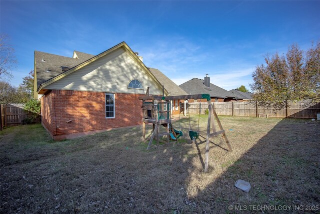 16304 Bandera, Oklahoma City, OK 73013 - rear view of house featuring brick siding, a fenced backyard, and roof with shingles