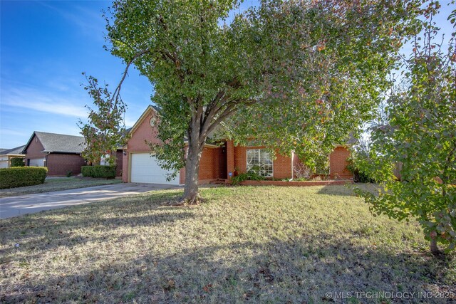 16304 Bandera, Oklahoma City, OK 73013 - obstructed view of property with a garage, concrete driveway, brick siding, and a front yard