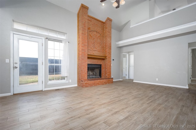16304 Bandera, Oklahoma City, OK 73013 - unfurnished living room featuring high vaulted ceiling, light wood finished floors, and a brick fireplace