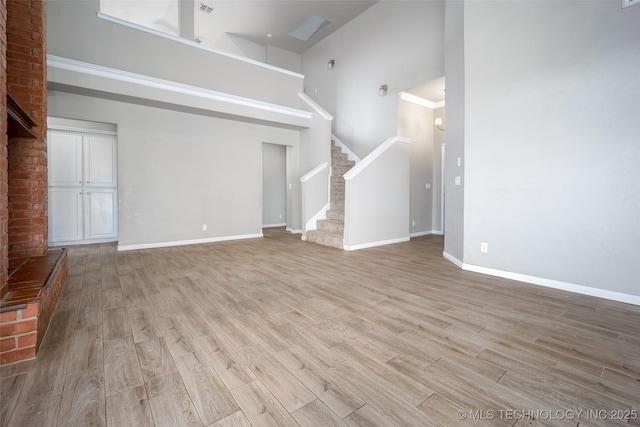 16304 Bandera, Oklahoma City, OK 73013 - unfurnished living room with a high ceiling, light wood-style floors, and stairs
