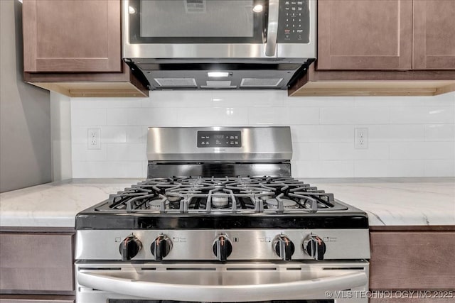 3729 S 150th E Ave, Tulsa, OK 74134 - kitchen featuring appliances with stainless steel finishes, tasteful backsplash, and light stone countertops