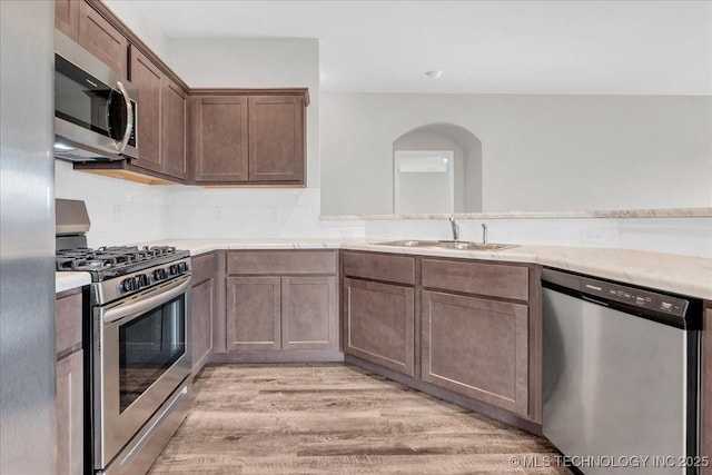 3729 S 150th E Ave, Tulsa, OK 74134 - kitchen featuring appliances with stainless steel finishes, light wood finished floors, arched walkways, and light countertops