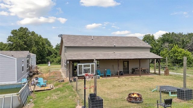 32528 W 261st St S, Bristow, OK 74010 - back of property with a fire pit, a patio, view of scattered trees, and roof with shingles