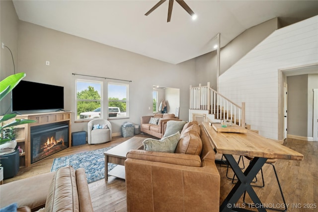 32528 W 261st St S, Bristow, OK 74010 - living area with wood finished floors, high vaulted ceiling, ceiling fan, a glass covered fireplace, and stairs