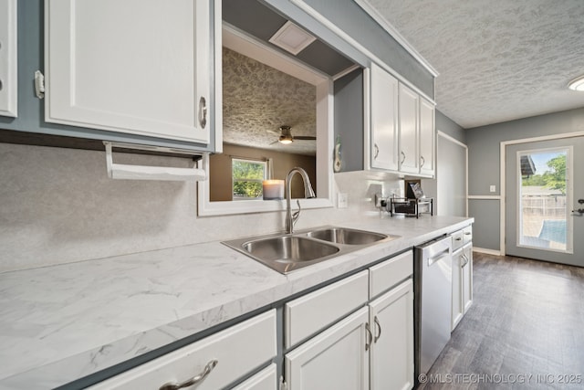 208 N Davis Ave W, Claremore, OK 74017 - kitchen featuring a textured ceiling, stainless steel dishwasher, white cabinetry, light countertops, and wood finished floors