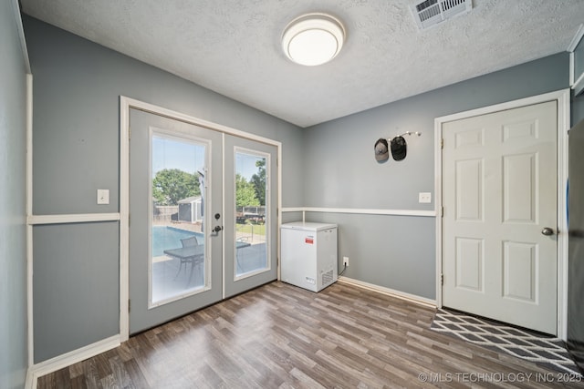 208 N Davis Ave W, Claremore, OK 74017 - entryway featuring french doors, wood finished floors, and a textured ceiling