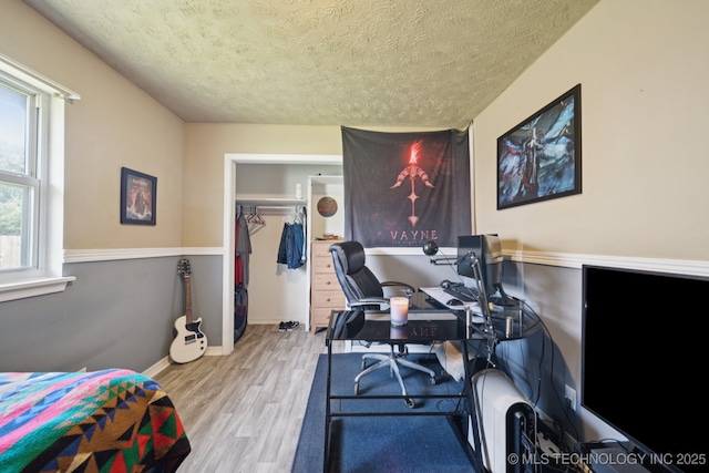 208 N Davis Ave W, Claremore, OK 74017 - bedroom featuring a textured ceiling, wood finished floors, and a desk
