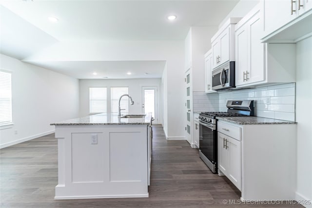 304 S 25th St, Collinsville, OK 74021 - kitchen featuring stainless steel appliances, light stone counters, an island with sink, white cabinetry, and dark wood-type flooring