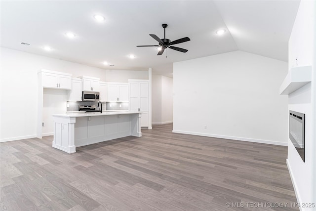 302 S 26th St, Collinsville, OK 74021 - kitchen featuring appliances with stainless steel finishes, a ceiling fan, light wood finished floors, light countertops, and open floor plan