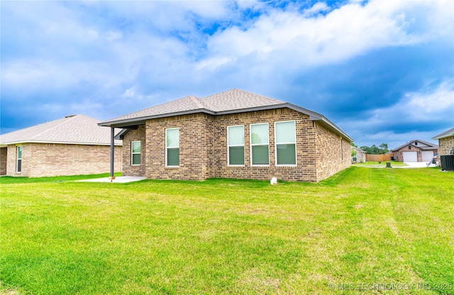 302 S 26th St, Collinsville, OK 74021 - back of property with a yard, brick siding, a shingled roof, and a patio area