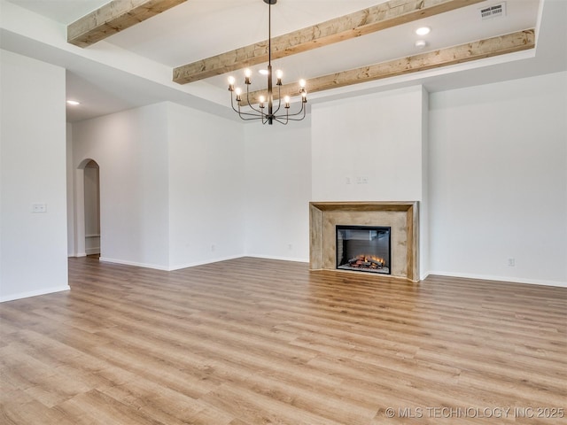 7202 E 132nd St S, Bixby, OK 74008 - unfurnished living room featuring arched walkways, light wood-type flooring, beamed ceiling, a chandelier, and a high end fireplace