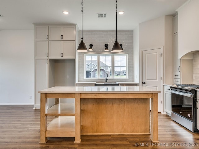 7202 E 132nd St S, Bixby, OK 74008 - kitchen featuring electric range, tasteful backsplash, light countertops, decorative light fixtures, and wood finished floors