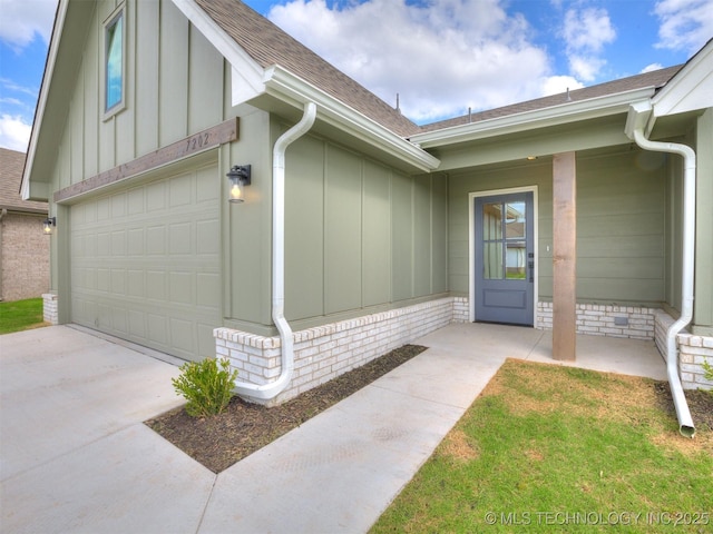 7202 E 132nd St S, Bixby, OK 74008 - view of exterior entry featuring board and batten siding, a shingled roof, a garage, and driveway