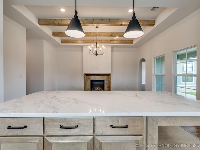 7202 E 132nd St S, Bixby, OK 74008 - kitchen featuring beam ceiling, arched walkways, light stone countertops, open floor plan, and a fireplace