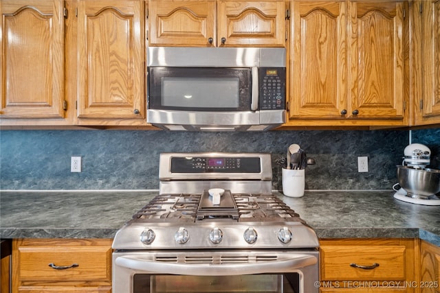 1600 S Ironwood Ave, Broken Arrow, OK 74012 - kitchen featuring stainless steel appliances, decorative backsplash, and dark countertops