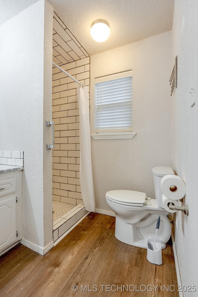 2520 Arlington Blvd, Ada, OK 74820 - bathroom with wood finished floors, a stall shower, and a textured ceiling
