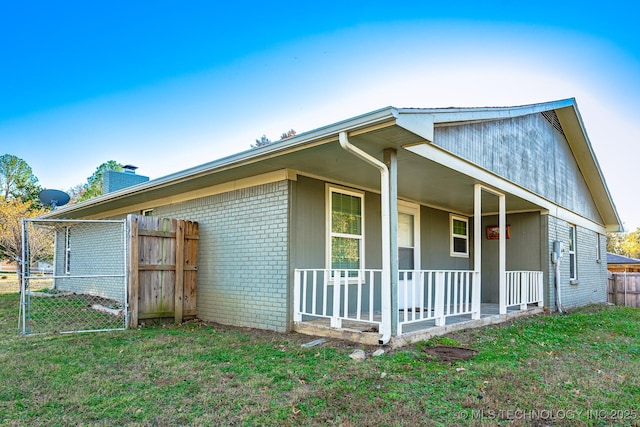 2520 Arlington Blvd, Ada, OK 74820 - view of side of home featuring brick siding, covered porch, and a chimney