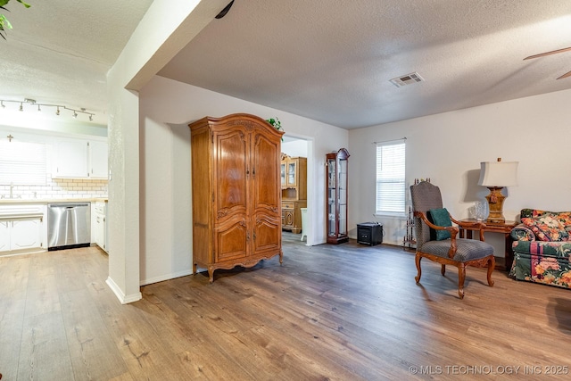 2520 Arlington Blvd, Ada, OK 74820 - sitting room with light wood-type flooring, a textured ceiling, and a ceiling fan