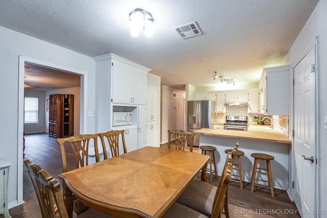 2520 Arlington Blvd, Ada, OK 74820 - dining space featuring a textured ceiling and dark wood finished floors