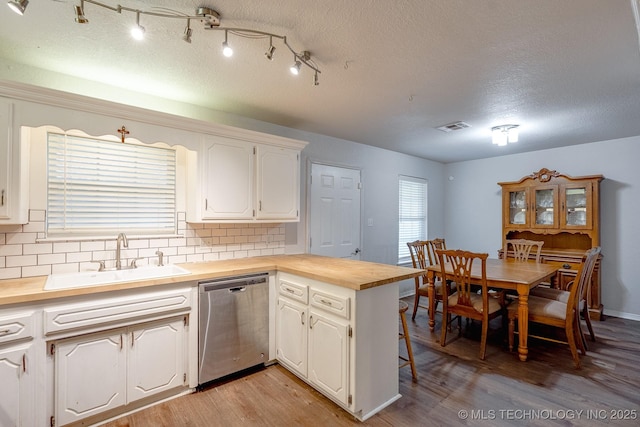 2520 Arlington Blvd, Ada, OK 74820 - kitchen featuring dishwasher, wooden counters, light wood-style flooring, a peninsula, and tasteful backsplash