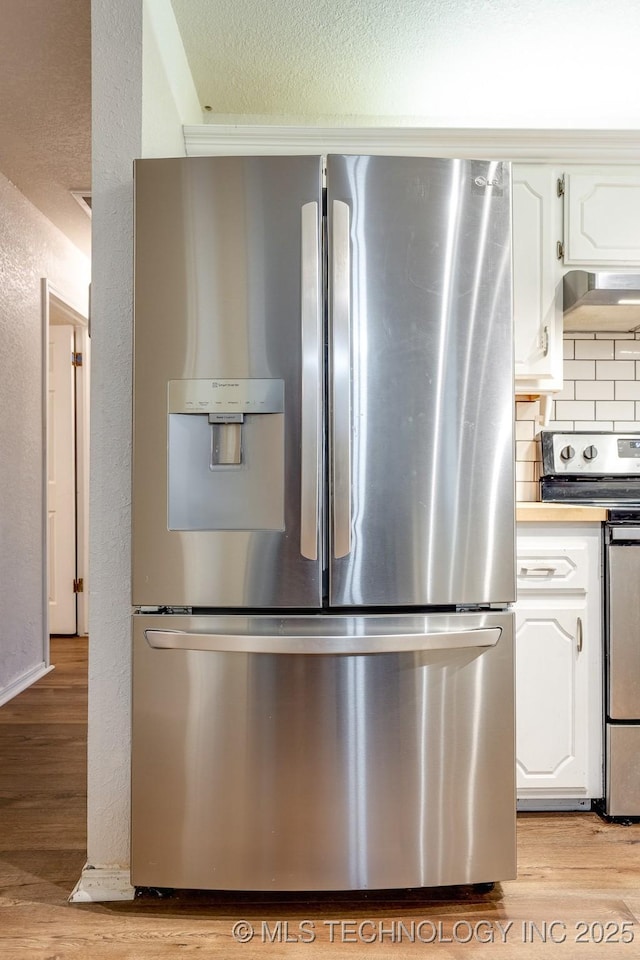 2520 Arlington Blvd, Ada, OK 74820 - kitchen featuring appliances with stainless steel finishes, light wood-type flooring, white cabinetry, a textured wall, and a textured ceiling