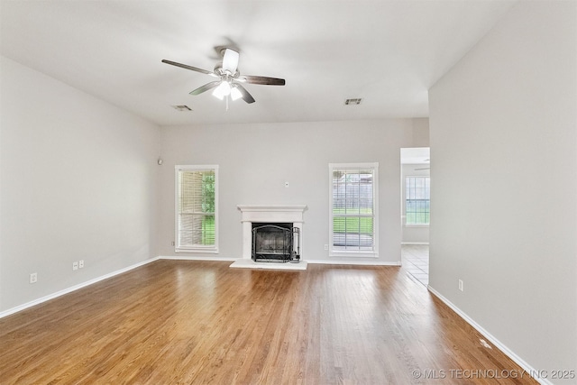 12003 S Tamarack St W, Jenks, OK 74037 - unfurnished living room featuring plenty of natural light, wood finished floors, a fireplace with raised hearth, and a ceiling fan