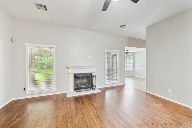 12003 S Tamarack St W, Jenks, OK 74037 - unfurnished living room featuring a ceiling fan, plenty of natural light, and a fireplace with raised hearth