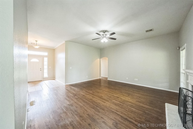 12003 S Tamarack St W, Jenks, OK 74037 - unfurnished living room with wood finished floors, a ceiling fan, healthy amount of natural light, and arched walkways