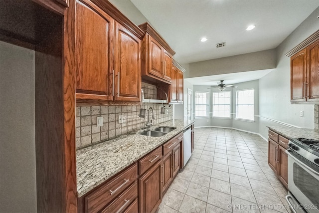 12003 S Tamarack St W, Jenks, OK 74037 - kitchen featuring stainless steel appliances, tasteful backsplash, light stone counters, a ceiling fan, and light tile patterned flooring