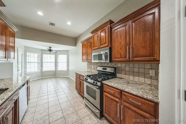 12003 S Tamarack St W, Jenks, OK 74037 - kitchen with stainless steel appliances, backsplash, light stone counters, ceiling fan, and light tile patterned flooring