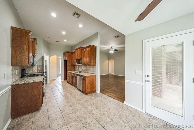 12003 S Tamarack St W, Jenks, OK 74037 - kitchen featuring ceiling fan, appliances with stainless steel finishes, arched walkways, backsplash, and recessed lighting