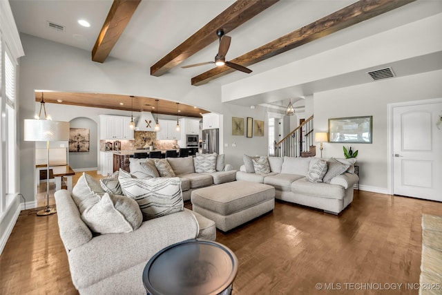 6108 E 95th St, Sperry, OK 74073 - living room with ceiling fan, wood finished floors, stairs, beamed ceiling, and arched walkways