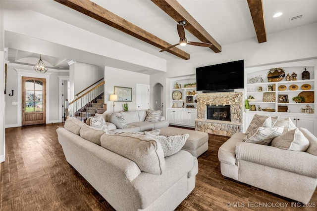 6108 E 95th St, Sperry, OK 74073 - living room featuring a ceiling fan, a stone fireplace, arched walkways, stairs, and dark wood-style flooring