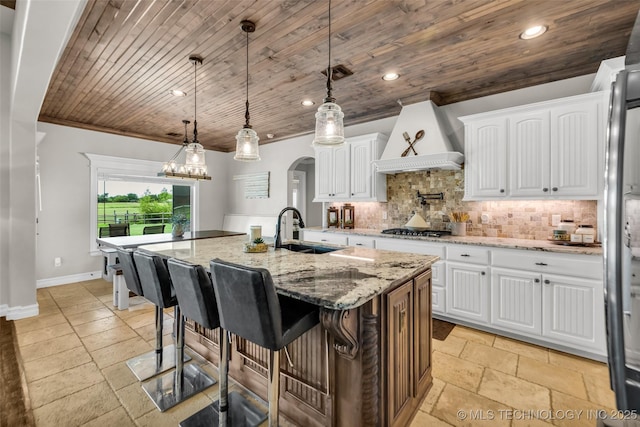6108 E 95th St, Sperry, OK 74073 - kitchen with wooden ceiling, stainless steel gas cooktop, stone tile floors, tasteful backsplash, and custom exhaust hood
