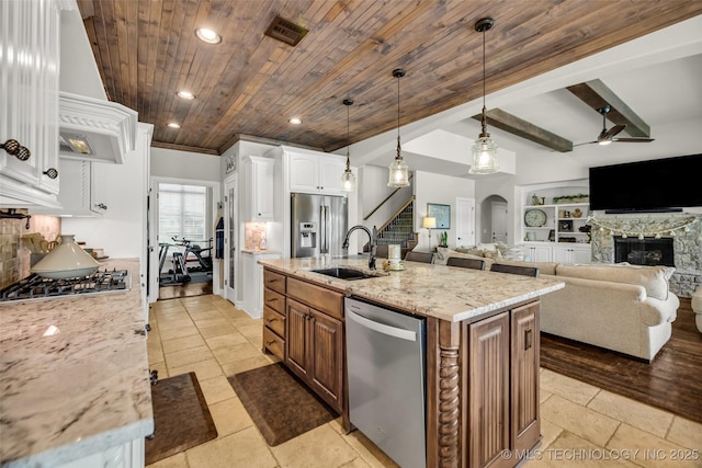 6108 E 95th St, Sperry, OK 74073 - kitchen with stainless steel appliances, a wooden ceiling with exposed beams, custom exhaust hood, a ceiling fan, and a fireplace