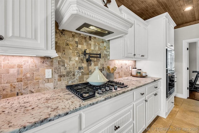 6108 E 95th St, Sperry, OK 74073 - kitchen with stainless steel appliances, premium range hood, white cabinets, light stone countertops, and tasteful backsplash