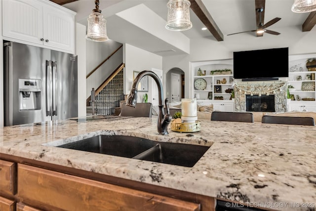 6108 E 95th St, Sperry, OK 74073 - kitchen with stainless steel fridge with ice dispenser, light stone countertops, ceiling fan, beam ceiling, and white cabinets