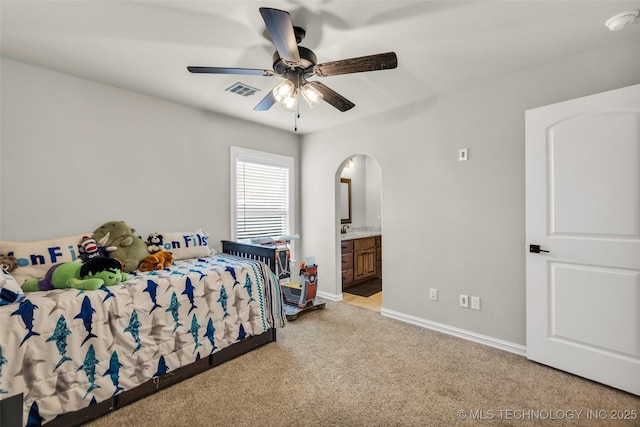6108 E 95th St, Sperry, OK 74073 - carpeted bedroom with ensuite bathroom, arched walkways, and a ceiling fan