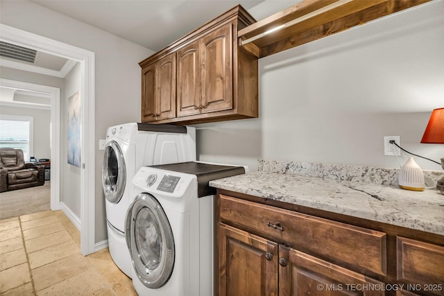 6108 E 95th St, Sperry, OK 74073 - laundry area featuring cabinet space, washer and clothes dryer, and stone tile flooring