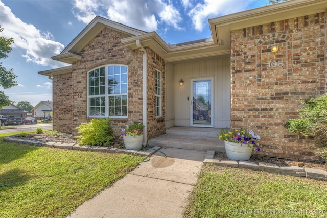 108 W 135th St, Skiatook, OK 74070 - property entrance featuring a yard and brick siding