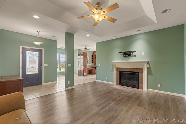 108 W 135th St, Skiatook, OK 74070 - unfurnished living room featuring a ceiling fan, wood finished floors, a premium fireplace, recessed lighting, and a raised ceiling